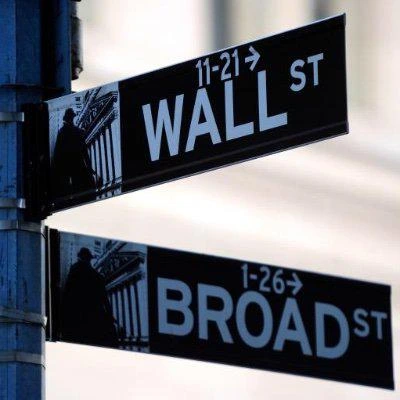 Wall Street and Broad Street signs on a street corner